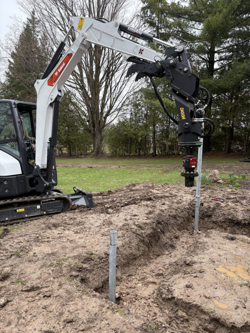 Mini excavator with auger drilling post holes
